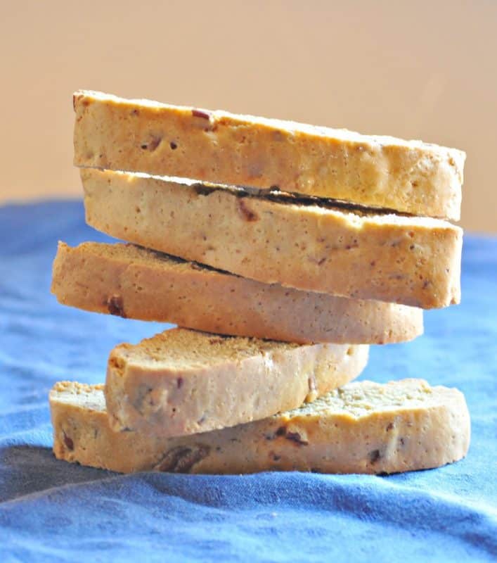Homemade Pecan Biscotti Recipe shown stacked on blue table 