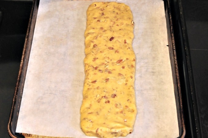 Pecan biscotti recipe dough on a baking tray going into the oven