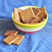 Homemade Wheat Thins Recipe shown in a bowl on blue tablecloth
