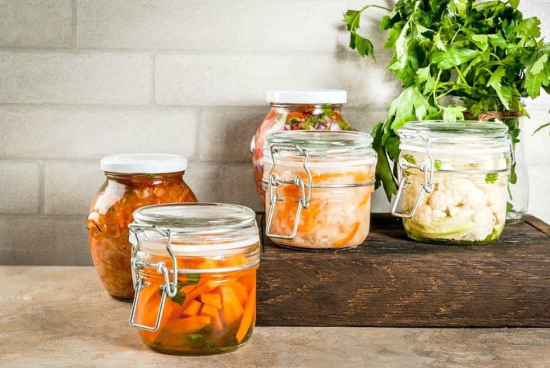 Fermented foods shown on counter with cutting board.