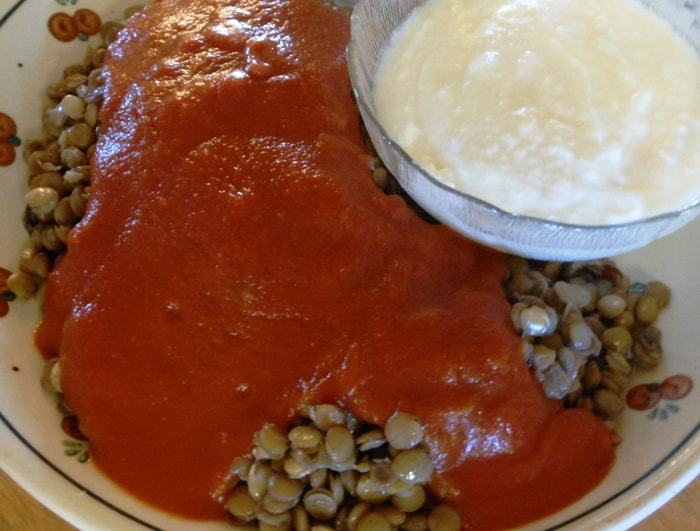 A close up of Egyptian lentils recipe made and topped with tomato sauce and yogurt