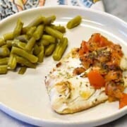 Tomato Basil Grilled Fish recipe shown close up with napkin and green beans.