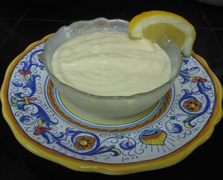 A photo of Italian cream in a glass bowl with a slice of lemon