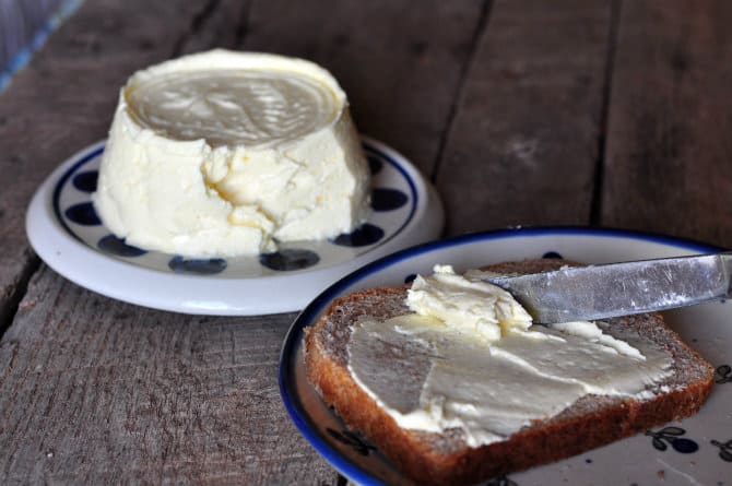 a photo of homemade butter being spread on a slice of bread