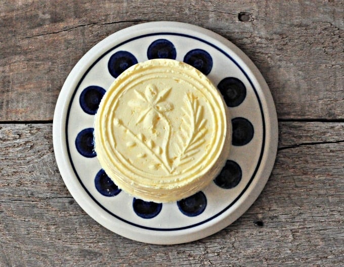 An overhead shot of molded butter on a small white plate