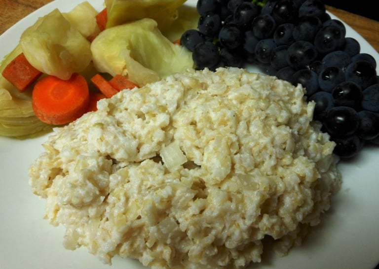 A photo of curd rice on a plate with vegetables