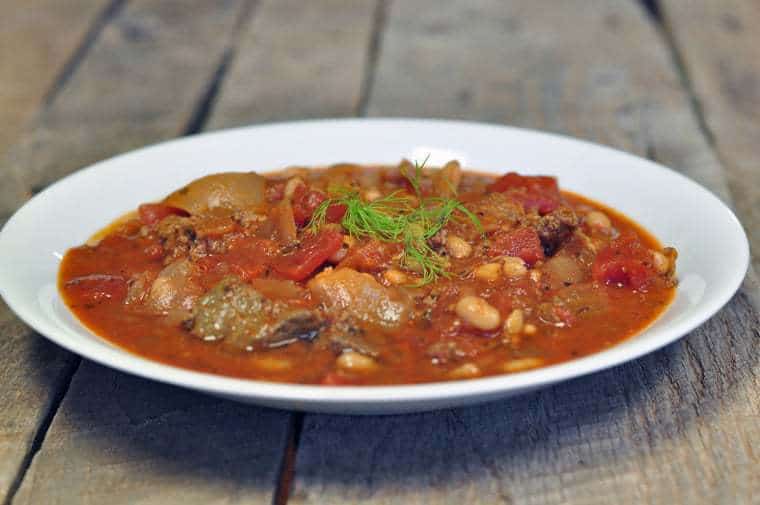 A photo of beef chili for a crowd on a white plate 