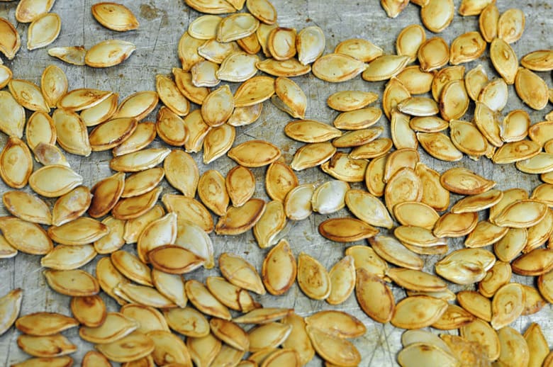 Toasted pumpkin seeds on a large baking tray