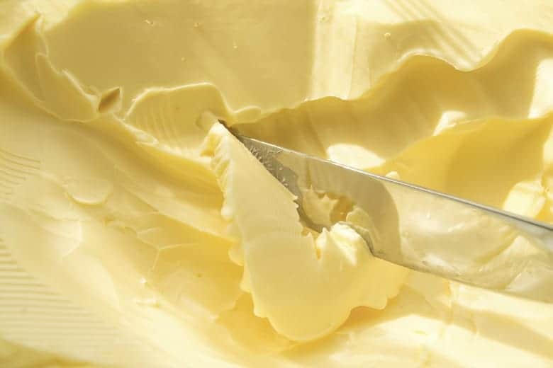 Closeup of a knife in margarine from the post, Is Margarine Harmful?