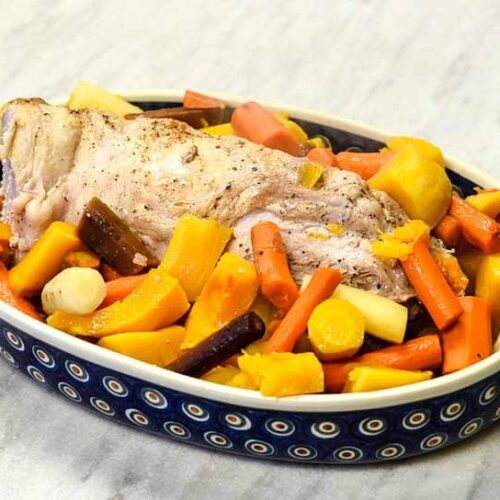 Oven Roasted Pork Loin with veggies in a polish pottery dish.