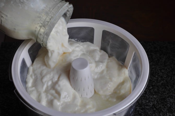 A process shot for how to make Greek yogurt, pouring it into a strainer