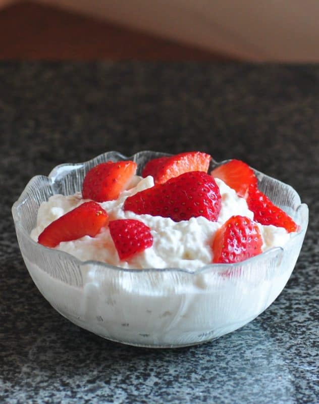 How to Make Cottage Cheese - Cottage Cheese Recipe shown with strawberries in a bowl.