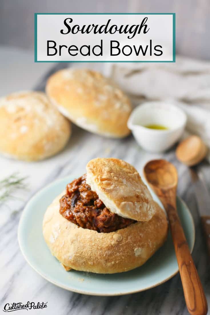 Sourdough Bread Bowls show filled with soup on plate with wooden spoon and text overlay.