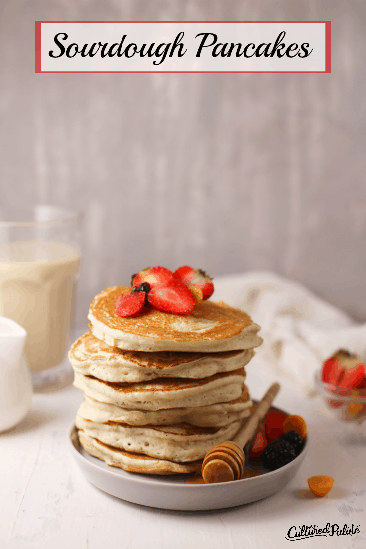 Sourdough Pancakes on white plate with milk in background and text overlay.