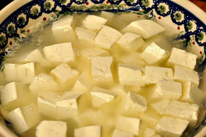 homemade feta cheese covered with water in a bowl