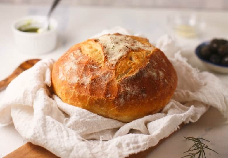 Basic Sourdough Bread shown on tea bowl and cutting board.