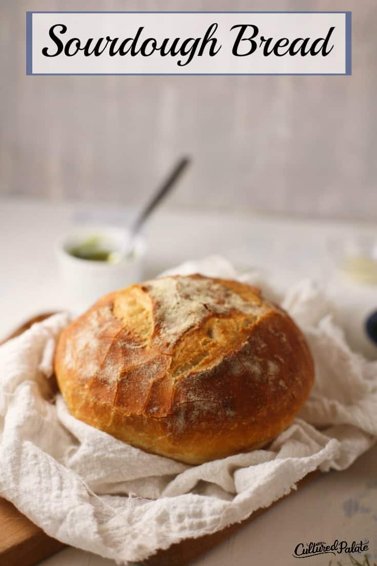 Basic Sourdough Bread Recipe shown made into an artisan loaves on white table.