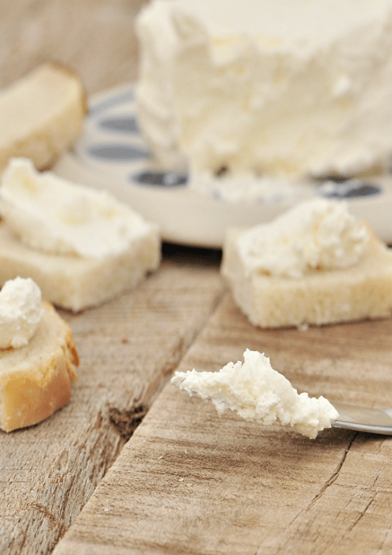 How to Make Cream Chese - Homemade Cream Cheese shown on knife and chunks of bread
