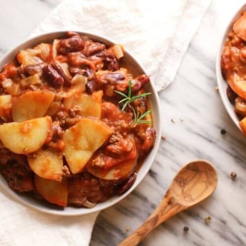 Crockpot Chili Recipe shown in white bowl from above on marble background.