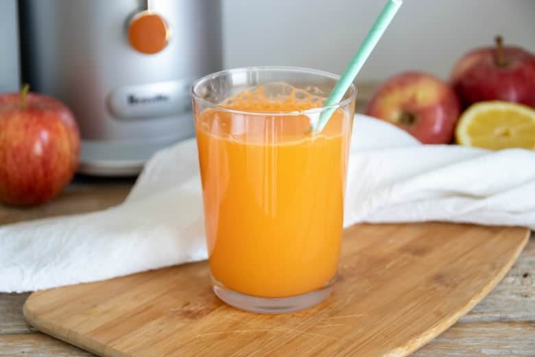 This is the Easiest Carrot Juice Recipe Ever! Sometimes I am late jumping on the bandwagon, and this is one of those times - with carrot juice recipes. #myculturedpalate #carrotjuicerecipes #juicerecipe #rawjuice Easiest carrot juice recipe shown ready to drink in glass.