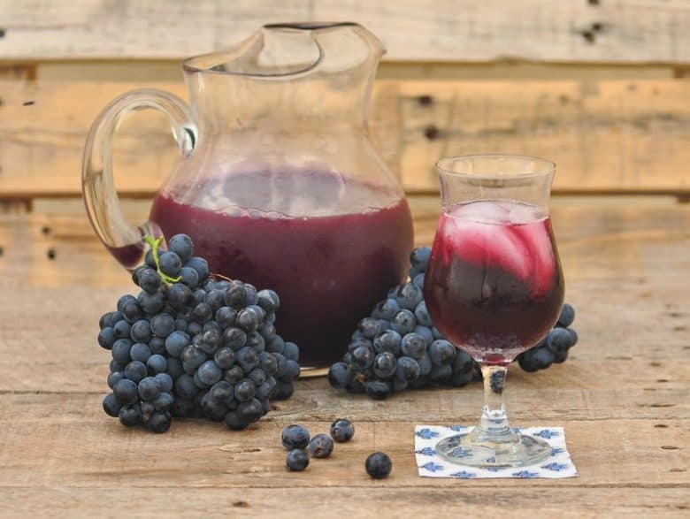 red wine sangria recipe shown in glass with grapes