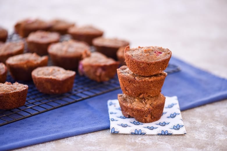Gluten Free Strawberry Muffins stacked up on top of each other with more in the background