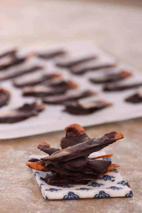 Healthy Chocolate Covered Bacon stacked up in a pile sitting on a work surface