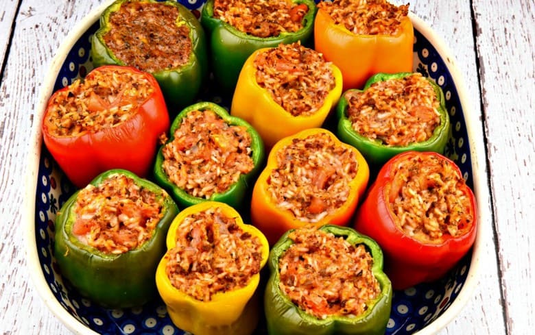 A baking tray filled with easy Stuffed Bell Peppers - stuffed peppers with rice ready to bake