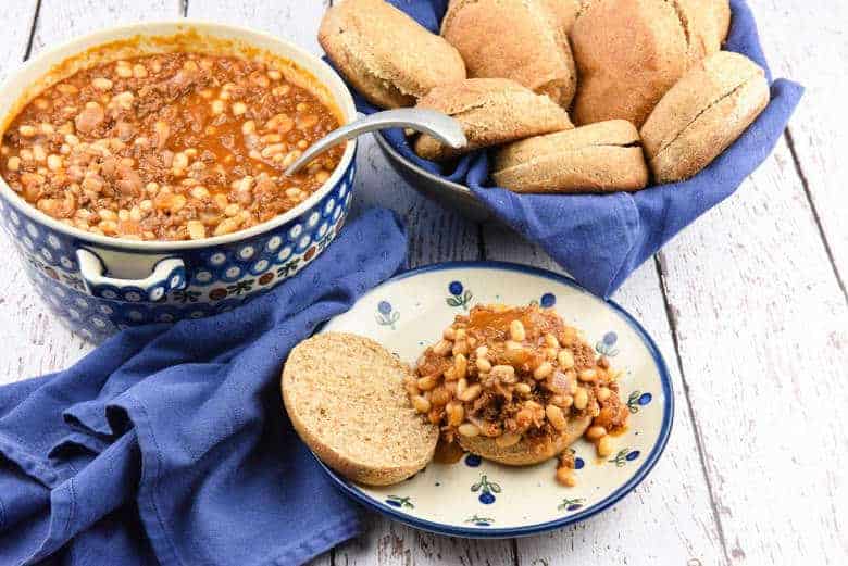 A photo of a big serving dish of beef and beans with rolls to make easy sloppy joes