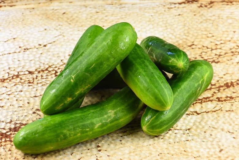 fresh cucumbers sitting on a work surface ready to be made into bread and butter pickles