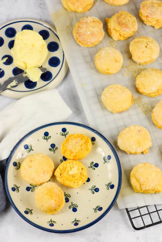 An overhead shot of Sweet Potato Biscuits on a blue and white plate with butter