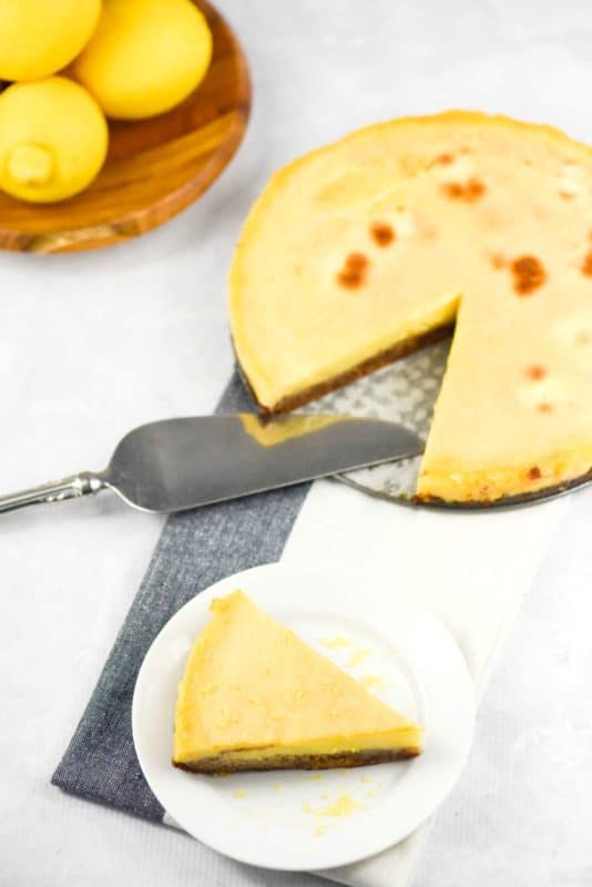 A photo of a lemon tart with a slice cut out on a plate made from easy lemon tart recipe