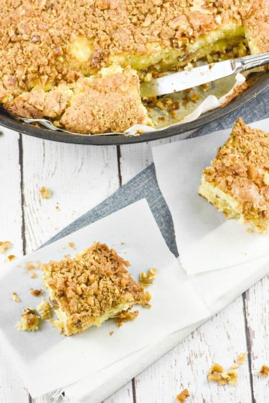Caramel Walnut Coffee Cake shown in cast iron pan with pieces cut on table