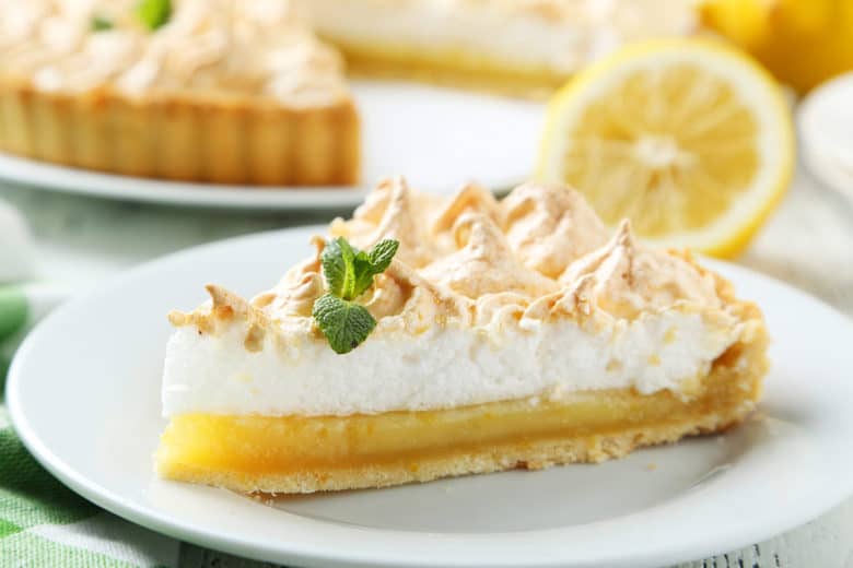 A piece of Lemon Meringue Pie made from Grandma's Lemon Meringue Pie Recipe shown on a white plate