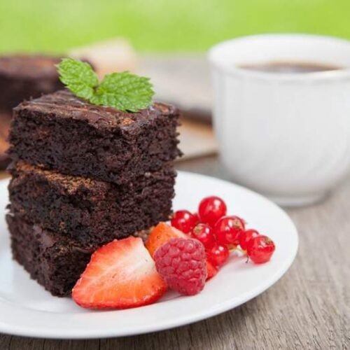 Three coconut flour brownies on a white plate