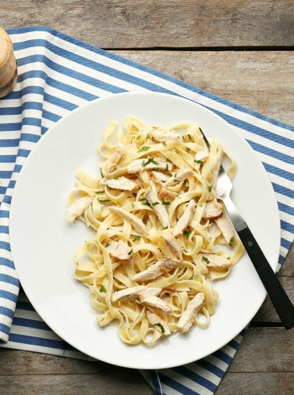 Plate with delicious Easy Chicken Alfredo Recipe on wooden table