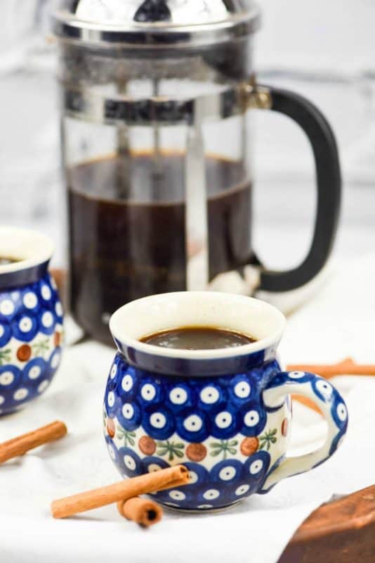 flavored coffee - Cinnamon Coffee shown in cup with french press in background