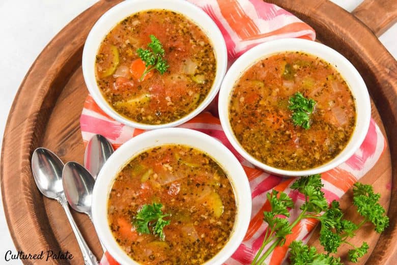 A photo of Instant Pot Minestrone Soup recipe in three white bowls on a wooden tray