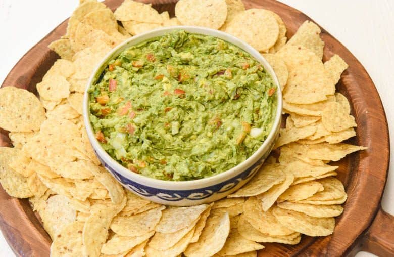 Easy Guacamole Recipe in a bowl surrounded by chips