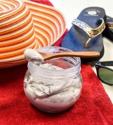 homemade sunscreen shown with sun hat, beach towel, sunglasses and flip flops