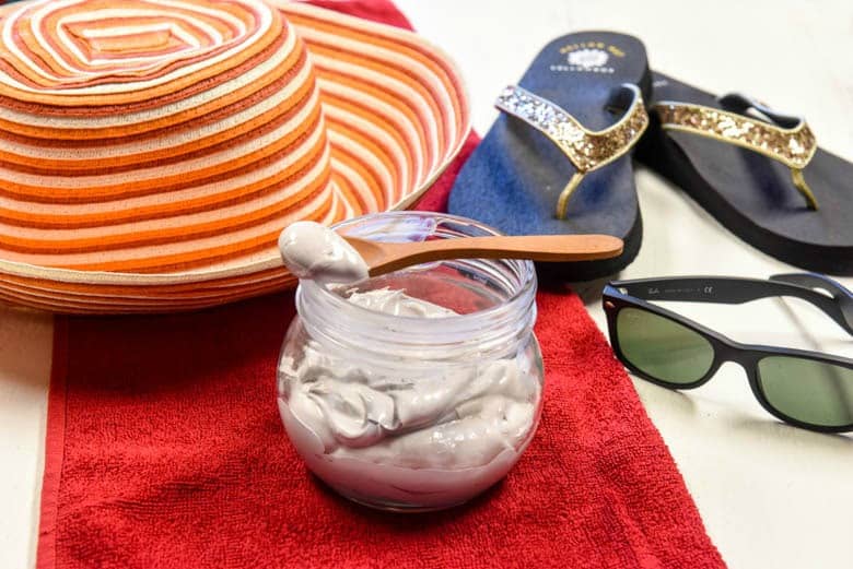 homemade sunscreen, DIY sunscreen shown with sun hat, beach towel, sunglasses and flip flops