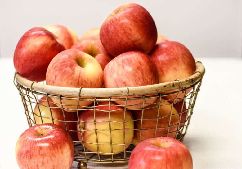 wire basket of apples shown for the Health Benefits of Apples article