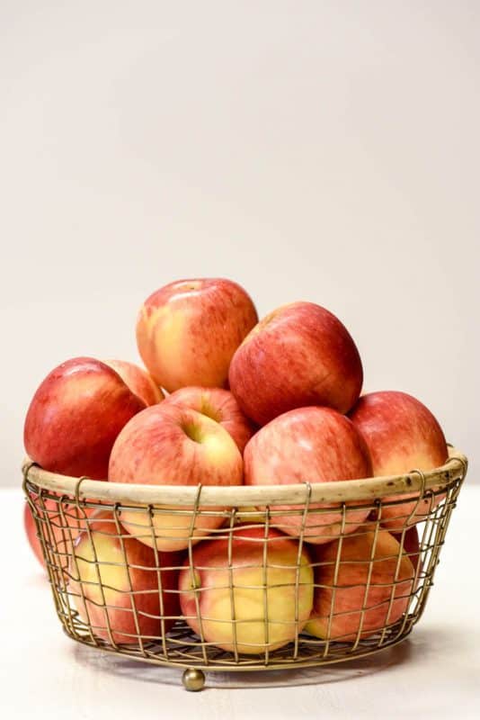 wire bowl of red apples