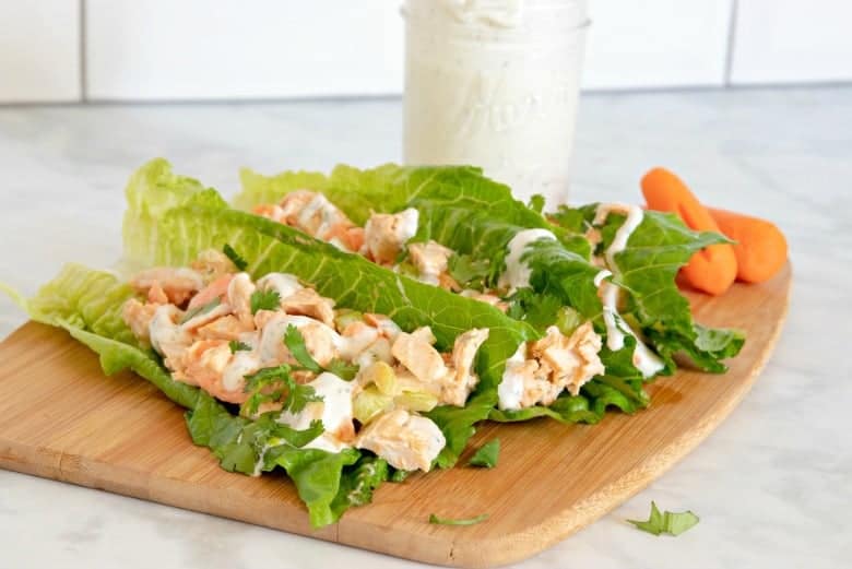 Buffalo Chicken Lettuce Wraps shown on a cutting board with homemade ranch in the background