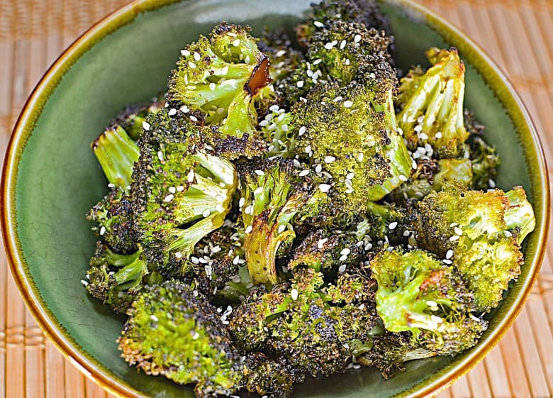 Sesame Oven Roasted Broccoli shown in a green bowl with sesame seeds on top