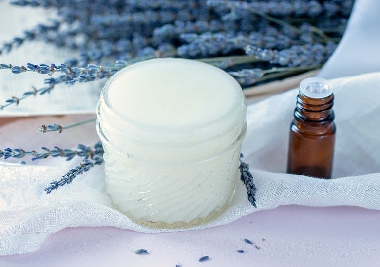 Best Sugar Scrub for Hands shown in glass jar with essential oil bottle and lavender in background