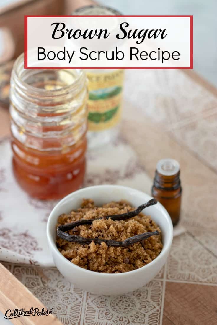 Brown Sugar Body Scrub shown in white bowl with essential oil, honey and vanilla bean on a tray with text overlay.