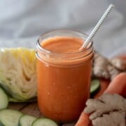 Carrot Juice Recipe for Weight Loss shown with white background and veggies around jar.