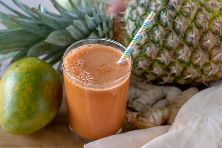 Fruit Punch Carrot Juice shown in glass with colorful straw.