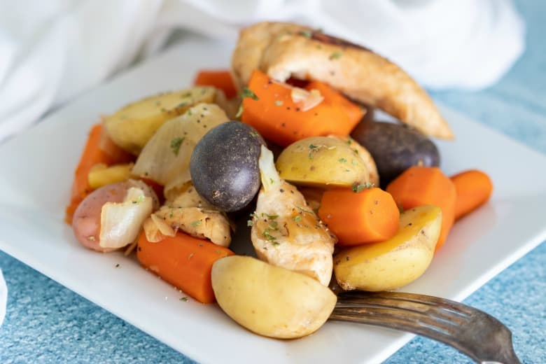 Complete Chicken Dinner in Crockpot shown in horizontal image on white plate.